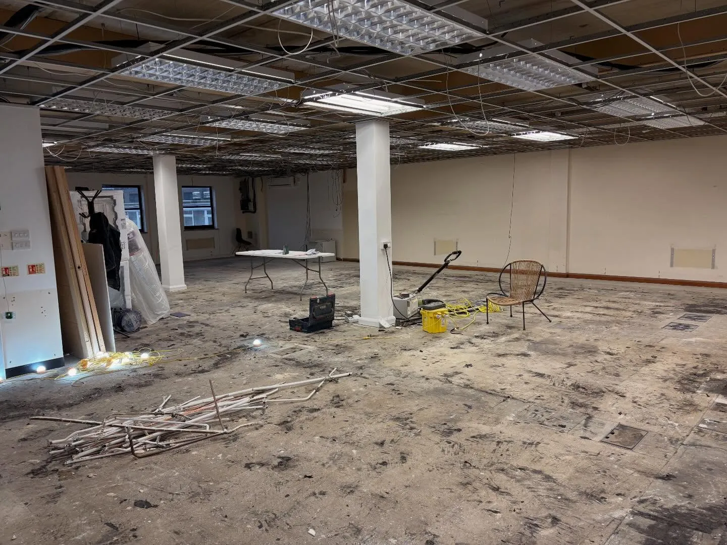 Office floor with old fluorescent fittings, opened ceiling grid and first fix cabling