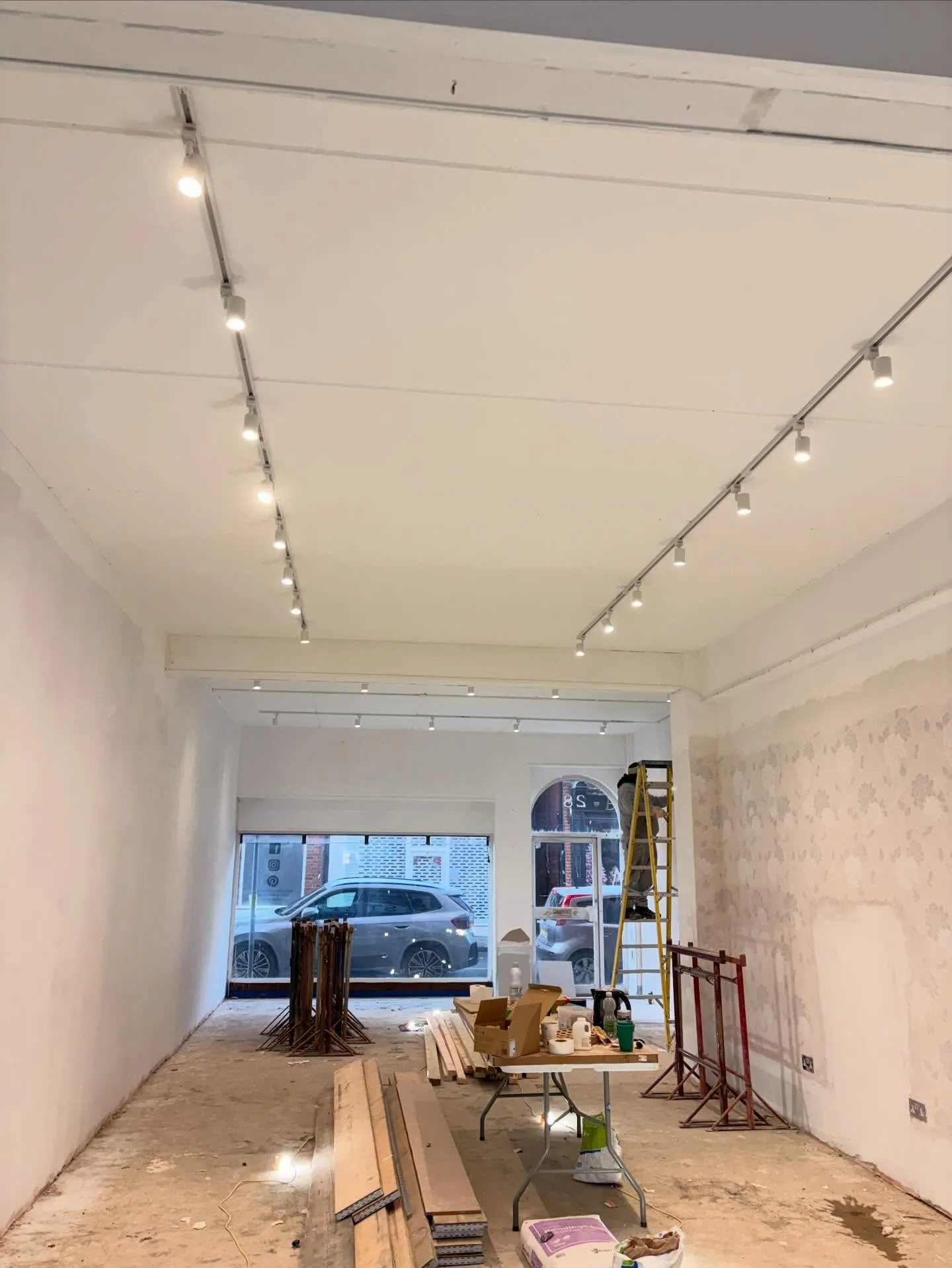 Track lighting and spotlights installed along a retail unit during fit-out